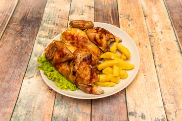 Baked whole roasted chicken halves with homemade potato chips on round white plate