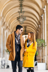 a couple of tourists walk along the alley in the warm light during the holidays. The lovers look at each other