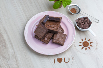 brownie pieces on a pink plate on a wooden base viewed from above