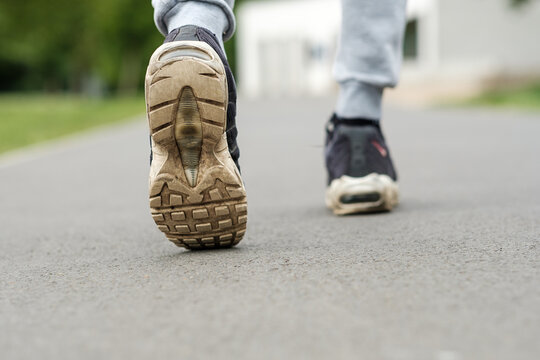 Close Up Of Old Dirty Shoes Trainers, Walking In A Park.