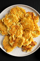 Homemade Potato Pancakes Latkes with Apple Sauce and Sour Cream on a black wooden surface, top view. Flat lay, overhead, from above.