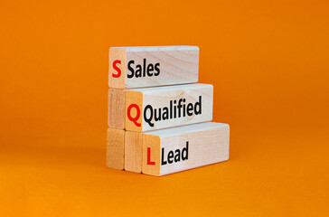 SQL sales qualified lead symbol. Wooden blocks with words 'SQL sales qualified lead'. Beautiful orange background. Business and SQL sales qualified lead concept. Copy space.