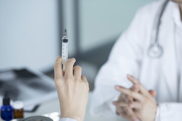 Doctor holding syringe in meeting