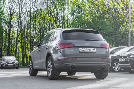 Audi Q5 SUV rear side view. Gray crossover SUV parked on the background of green trees
