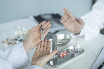 Doctor holding syringe in meeting