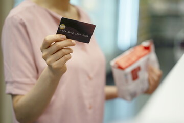 Woman shopping with credit card in supermarket