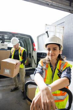 Portrait Confident Female Warehouse Worker Unloading Van