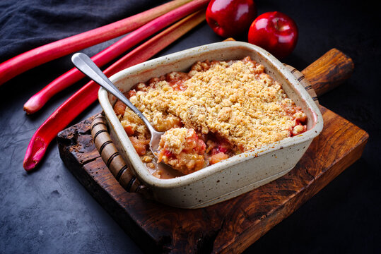 Traditional English crumble cake with rhubarb and apple with backed topping served as close-up in backing form