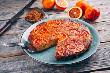 Modern style traditional Italian blood orange ricotta pie with fruits and almonds served as close-up on a Nordic design plate with copy space