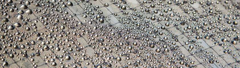 Water drops on the silver surface. Abstract background