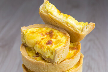 Lorraine cheese quiches stacked on wooden base