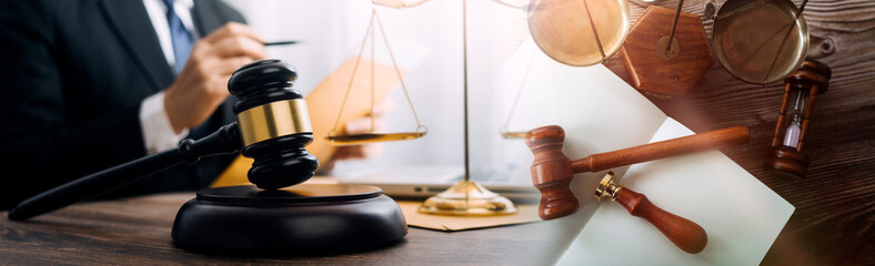Justice and law concept.Male judge in a courtroom with the gavel, working with, computer and...