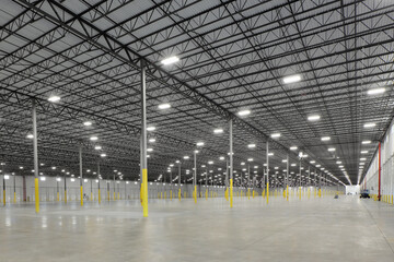 Massive empty steel warehouse with gray and yellow supports