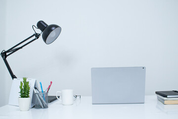 White desk, laptop and black lamp. Equipment on table. Modern office concept.