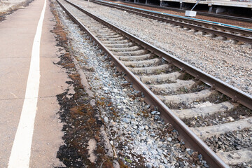 Fototapeta premium Rails, sleepers and railway platform in perspective.