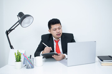 Cheerful businessman taking notes while working in the office.