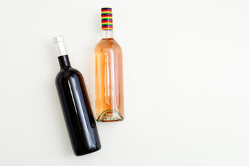 Rose wine bottle and red wine bottle . Minimalistic wine composition top view on white background. Two bottles of Wine brand mockup. Flat lay with copy space.