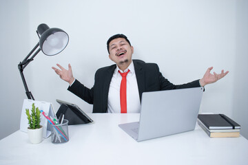 Young, happy businessman is working in his office.