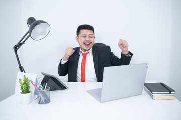 Young, happy businessman is working in his office.