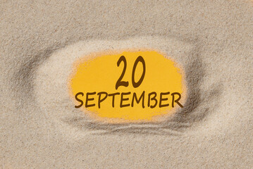 September 20. 20th day of the month, calendar date. Hole in sand. Yellow background is visible through hole. Autumn month, day of the year concept