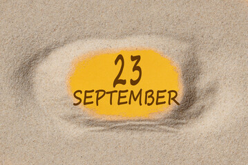 September 23. 23th day of the month, calendar date. Hole in sand. Yellow background is visible through hole. Autumn month, day of the year concept