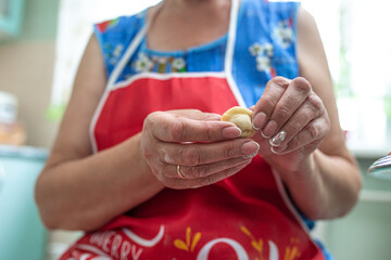 woman sculpts dumplings in the kitchen, hands close-up