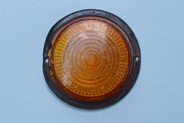 car detail from old red headlight cover on gray table