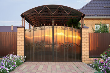 Wrought gates covered polycarbonate and a canopy before garage