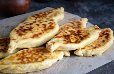 Delicious appetizing homemade khachapuri or khachin with cheese or meat or potatoes. A dish of Caucasian cuisine.