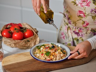 woman prepares a delicious mediterranean quinoa salad in her home kitchen