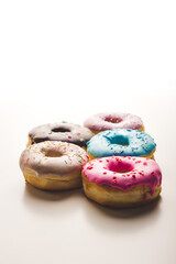 Multicolored doughnuts on isolated white background. sweet pastry dough filled with jam, chocolate, coated with sugar fudge with sprinkles. Text copy