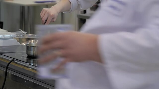 Chef melting butter in pot at cuisine of restaurant. Professional cooking, cookery, gastronomy and healthy food concept