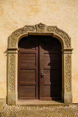 Renaissance Church of the Nativity Virgin Mary, historic center in medieval town, ancient stone portal, old wooden door, summer day, Opocno, Czech Republic
