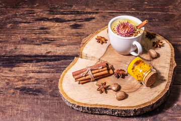 Golden turmeric milk with ice on bright yellow background