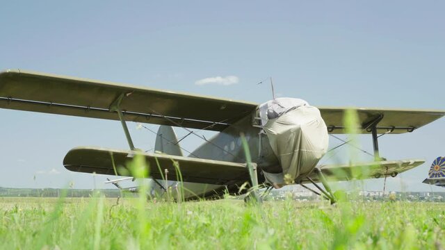 Old Soviet Military Plane Antonov An-2 Landing on Grass Blue Sky Background. High quality 4k footage