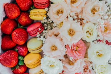 Close up of flower´s dressing with strawberries and colorful macarons