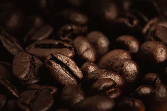 close up dark roasted coffee beans on heap, Low light picture style and showing detail with texture
