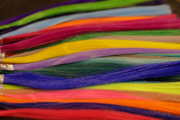 strands of natural dyed hair of bright colors in the palette on the table. selective focus 