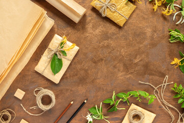 Gifts in paper wrapping, set of vintage yellow package paper, rolls, ropes and pencils for...