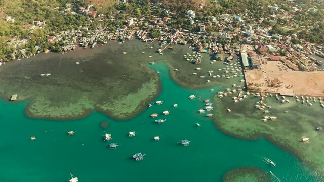 sea port, pier, cityscape Coron town with boats on Busuanga island, Philippines, Palawan. Coron city with slums and poor district. Seascape with mountains.