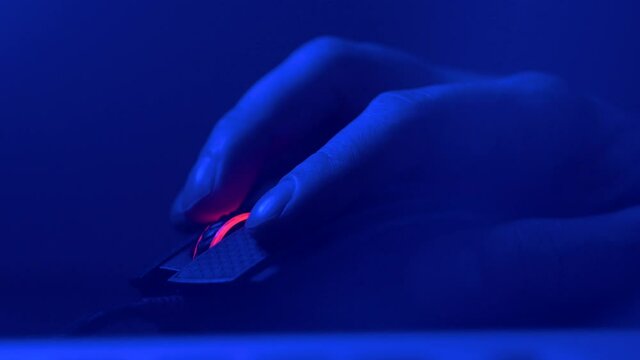 Close up of Hand over wireless Game Mouse on dark background The finger ready to click
