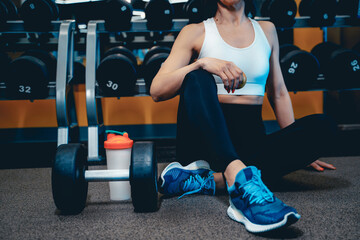 Fototapeta na wymiar girl in sports uniform sits on the floor in the gym and rests