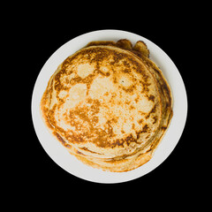 pancakes on a plate on a black background, top view