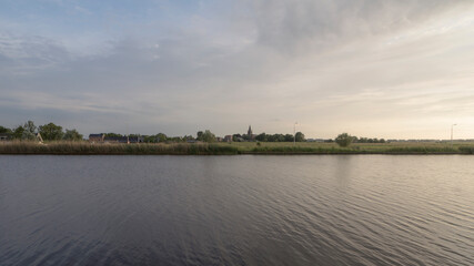 The Amstel river with the town of Nes aan de Amstel in the background during the evening