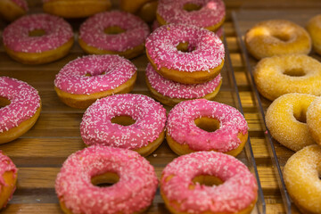 Close up view of pink donuts isolated on wooden background. Food and drink concept.