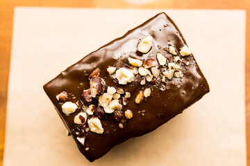 Top view of a natural organic chocolate brownie cake with nuts and chocolate cream on top. Brazilian organic artisanal bakery mall business concept.