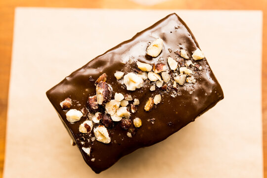 Top view of a natural organic chocolate brownie cake with nuts and chocolate cream on top. Brazilian organic artisanal bakery mall business concept.