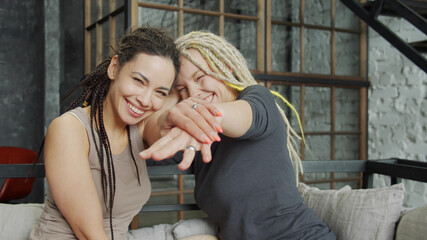 Lesbian couple celebrating their engagement showing the rings