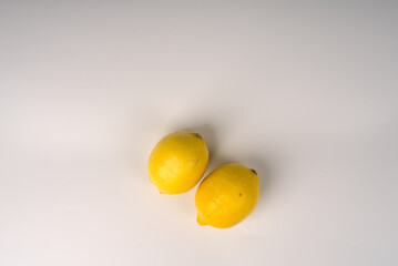 Two lemons on a white flatlay background.