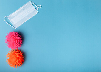 Coronaviruses or the other infectious microbes of orange and pink color sit near the medical mask...